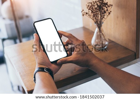 cell phone mockup blank white screen.man hand holding texting using mobile on desk at coffee shop.background empty space for advertise.work people contact marketing business,technology
