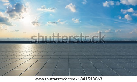 Empty concrete tiles floor with city background