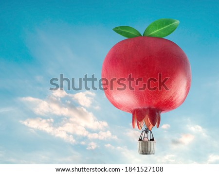 Pomegranate fruit shaped hot air balloon, Hot air balloon floating over a green hill Elements of nature and sky background, Tourism and travel concept Royalty-Free Stock Photo #1841527108