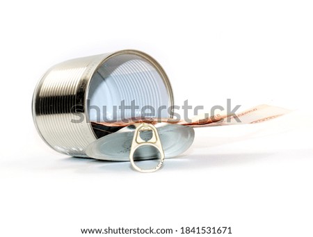 opened metal can with paper banknotes rubles