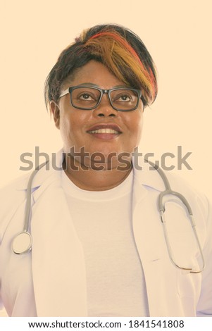 Face of happy fat black African woman doctor smiling and thinking while wearing eyeglasses