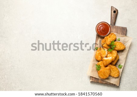 Tasty fried chicken nuggets on light grey table, top view. Space for text Royalty-Free Stock Photo #1841570560