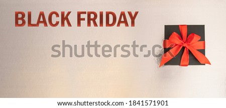 Black gift box with red bow on silver background for Black Friday SALE.Large inage for banner with copy space