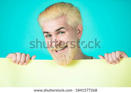 Man holding card, man with banner, isolated blue background, man showing empty card