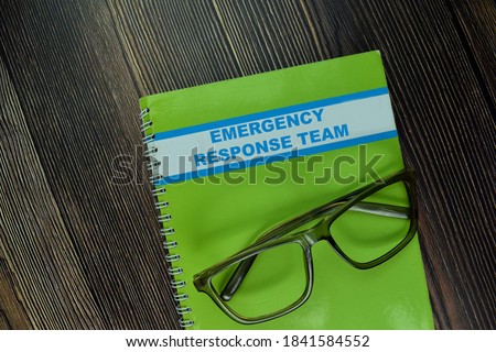 The Book of Emergency Response Team isolated on wooden table Royalty-Free Stock Photo #1841584552