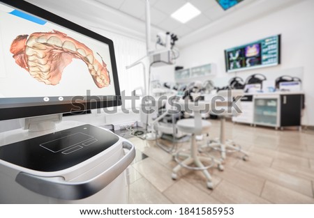 Snapshot of empty clean dental office. Interior of modern dental clinic. Computer screen with high precision digital jaw print on it on foreground. Royalty-Free Stock Photo #1841585953