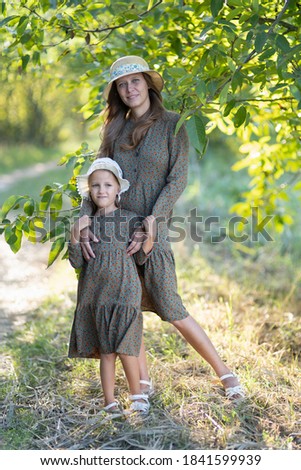 Mom and daughter, Woman and girl six years old on a walk, in nature