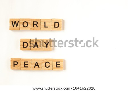 Top view of the words world peace day lined from square wooden tiles on white background.