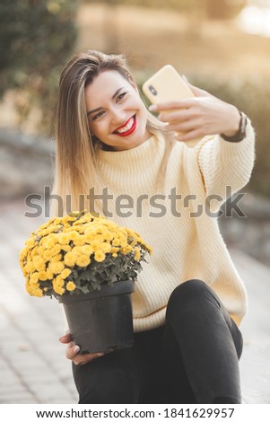 Beautiful lady on autumn background with yellow flowers