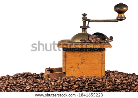 Old manual coffee grinder made of metal and wood with roasted coffee beans isolated on white background. Veneto, Italy, Europe. Royalty-Free Stock Photo #1841655223