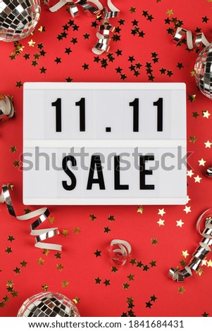 11.11 sale text on white lightbox, holiday ribbon and box on red background. Online shopping, singles day sale concept. Top view copy space 