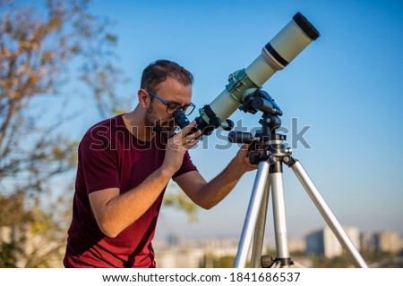 Amateur astronomer looking at the sky with a telescope. Royalty-Free Stock Photo #1841686537