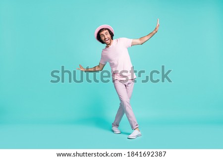 Full length photo of adorable guy dancing wear cap t-shirt trousers sneakers isolated on teal color background