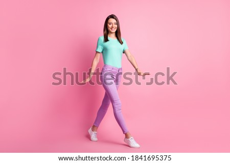 Photo portrait full body view of woman walking isolated on pastel pink colored background