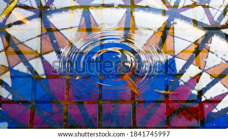 Full frame shot of multicolored window reflected on water, water drop undulation