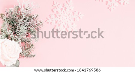 Christmas, winter composition. Xmas holiday decorations. Fir tree branches, flowers on pastel pink background. Christmas, New Year, winter concept. Flat lay, top view, copy space