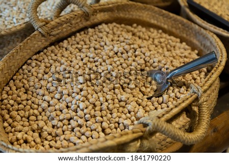 Closeup of toasted chickpeas in wicker basket for sale in store. Natural food