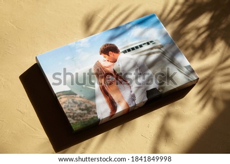 Canvas print with gallery wrap on surface with sunlight and shadow of leaves. Wedding photo printed on canvas
