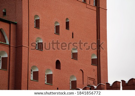 Scenic view on chaotic distribution of windows on red bricks walls of Trinity tower of Kremlin 