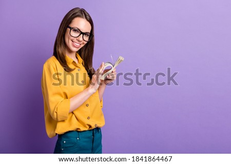 Photo of charming young girl shiny smile count stack cash wear spectacles yellow shirt isolated violet color background