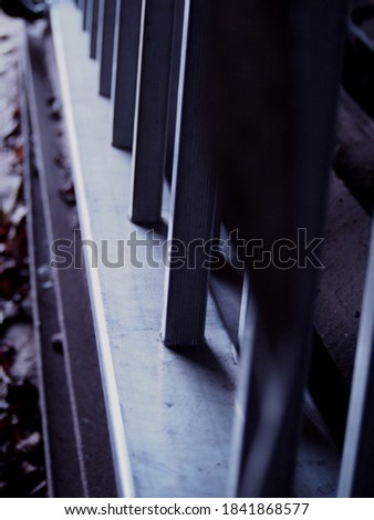 silver aluminum ladder lying on clay ground with old dry leaves in autumn, gloomy mood, gray background, depressed view in cloudy weather