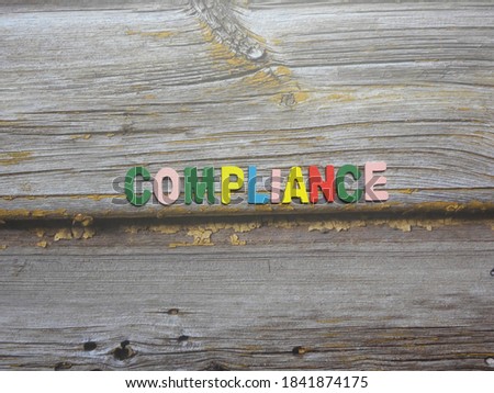 Word Compliance on wood background