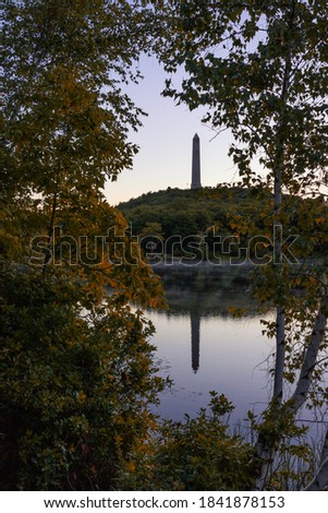 Tall obelisk monument on a mountain reflecting in still water at sunrise. High Point State Park, New Jersey