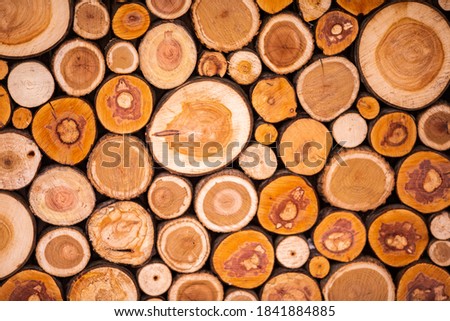 Christmas texture background of dry wooden log cabins. Woodpile of cut Lumber for forestry industry.