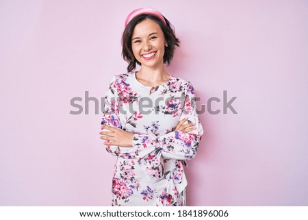 Young beautiful woman wearing casual clothes and diadem happy face smiling with crossed arms looking at the camera. positive person. 