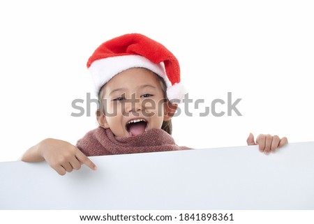 Portrait of a happy little girl wearing Santa hat Pointing a white panel isolated on white background holding a blank board Christmas billboard