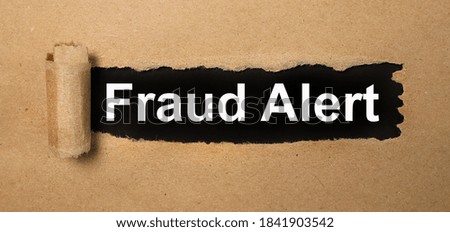 fraud alert, text on white paper on torn paper background