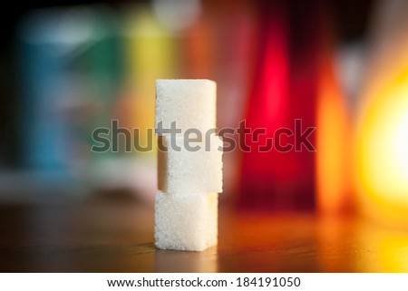 Sugar cubes lined with a padlock on color background