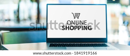 Laptop computer displaying online shopping logo. E-commerce