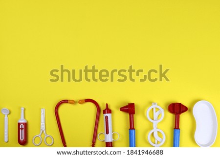 toy medical doctor's tools on a yellow background. Space for text