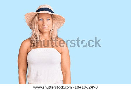 Middle age fit blonde woman wearing summer hat depressed and worry for distress, crying angry and afraid. sad expression. 