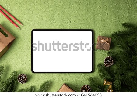 Blank screen Mockup tablet on green Christmas background.