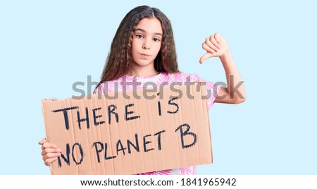 Cute hispanic child girl holding there is no planet b banner with angry face, negative sign showing dislike with thumbs down, rejection concept 