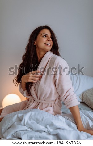 Young woman waking up after a good night's sleep in her bed