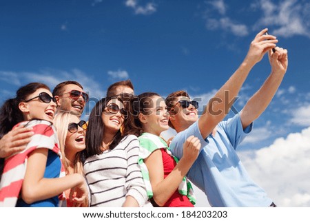 summer, holidays, vacation, happy people concept - group of friends taking selfie with smartphone