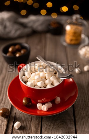 Hot chocolate with marshmallow in red cup on wooden table. Christams winter hot drink menu recipe