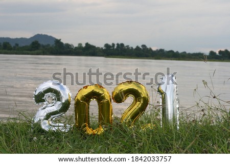 Happy new year 2021. Holiday golden metallic balloons number 2021. on a beautiful landscape background. tranquility and peace.