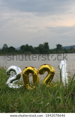 Happy new year 2021. Holiday golden metallic balloons number 2021. on a beautiful landscape background. tranquility and peace.