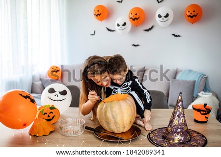 Mother and son in costumes decorating home for Halloween, everything need to be perfect when family gather around. Getting ready for Halloween 