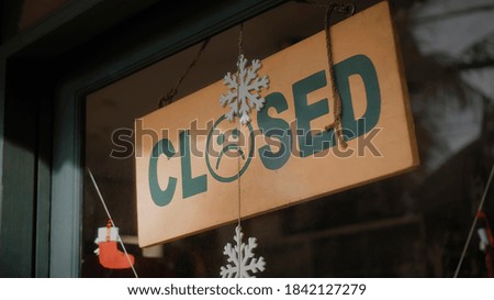 A sign hanging on the door of the institution with a glass window with the inscription closed with sad smile