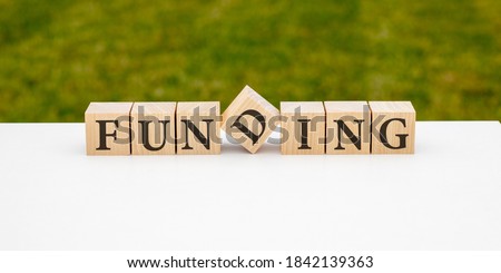 Funding word written on wood block. Saving Money for Funding and Business concept.
