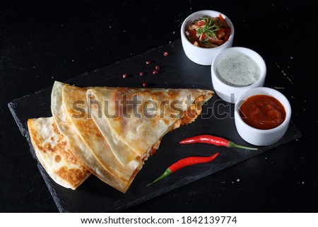Tortilla with meat and cheese with sauce