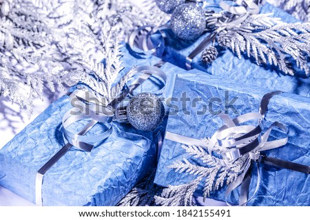 Christmas composition. Homemade gift, Christmas present box wrapped in blue paper, decorated  silver thuja branches, small silver balls , Selective focus