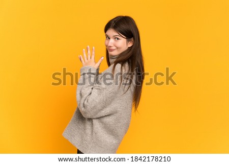 Young Ukrainian girl isolated on yellow background scheming something