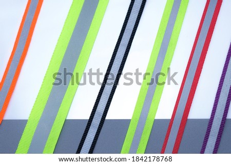 Reflective tape of different colors on a white background. textile sew-on reflective tape on clothes. gray reflective stripe retro-reflective element braid.