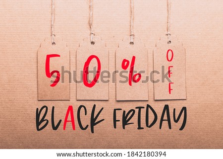 Text 50% off, black friday written on tags. Brown Kraft Paper Gift Tags on recycled brown paper as background, zero waste and sustainable living, shopping sale concept